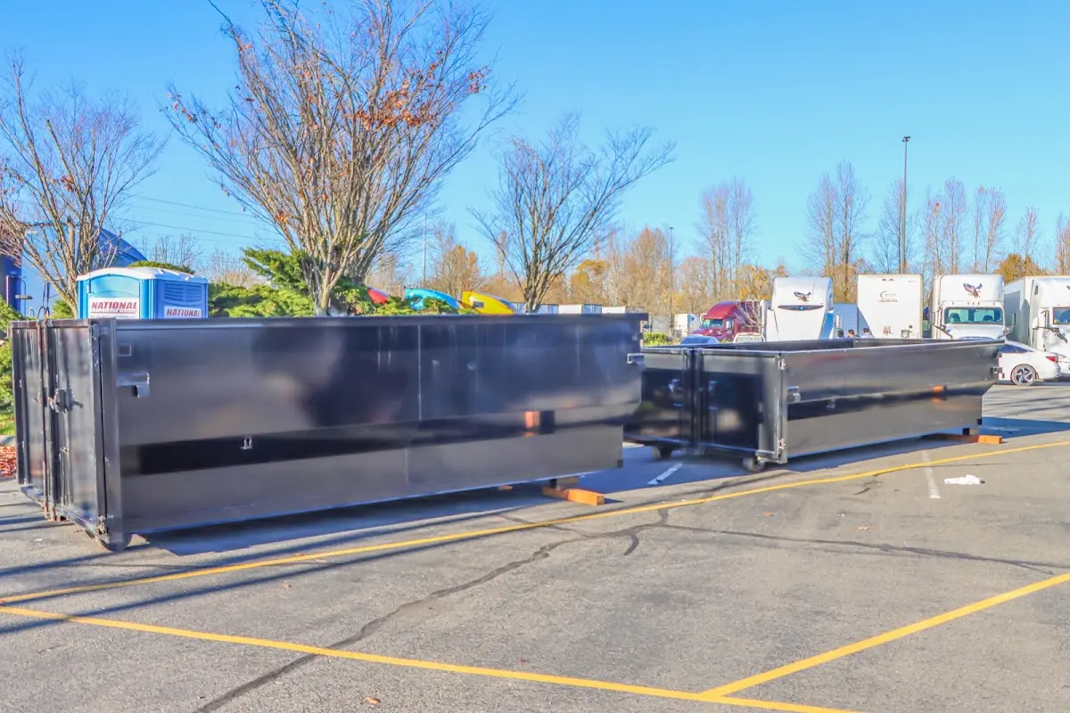 Professional dumpster rental service with roll-off container on residential driveway in East Pennsboro